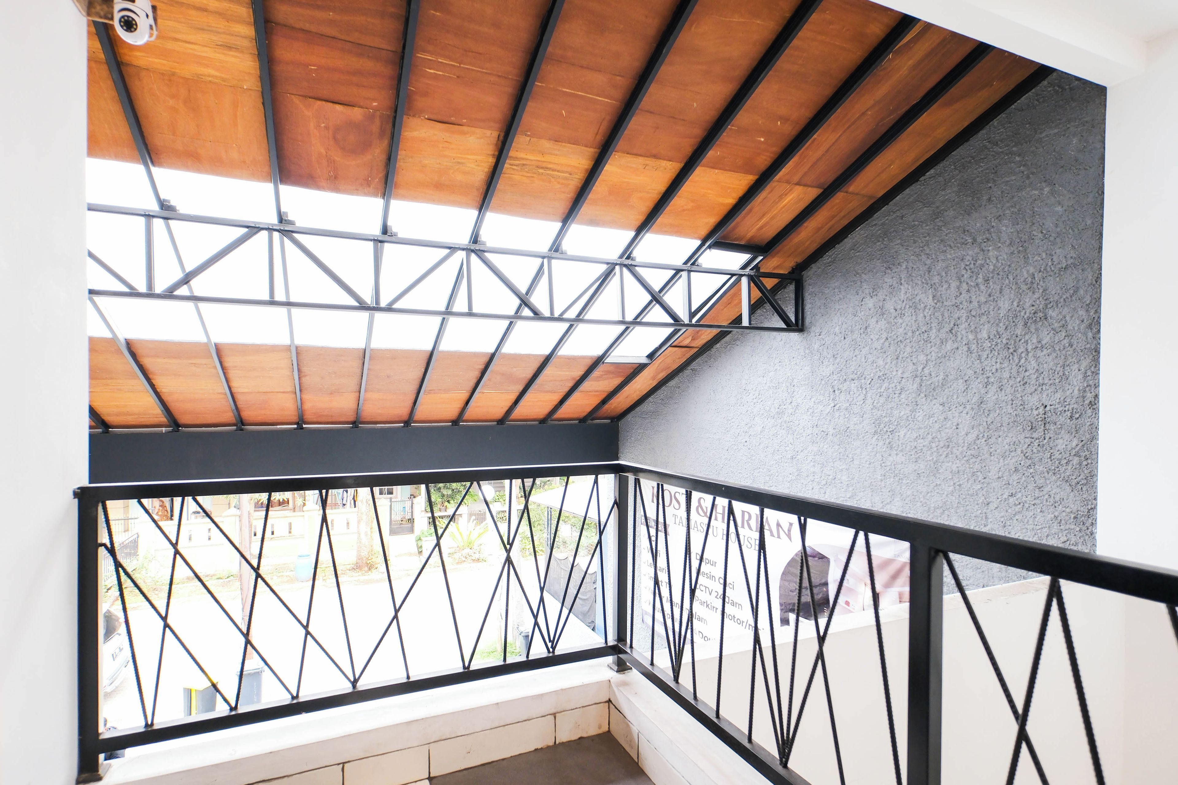 A balcony with a wooden ceiling and metal railing.