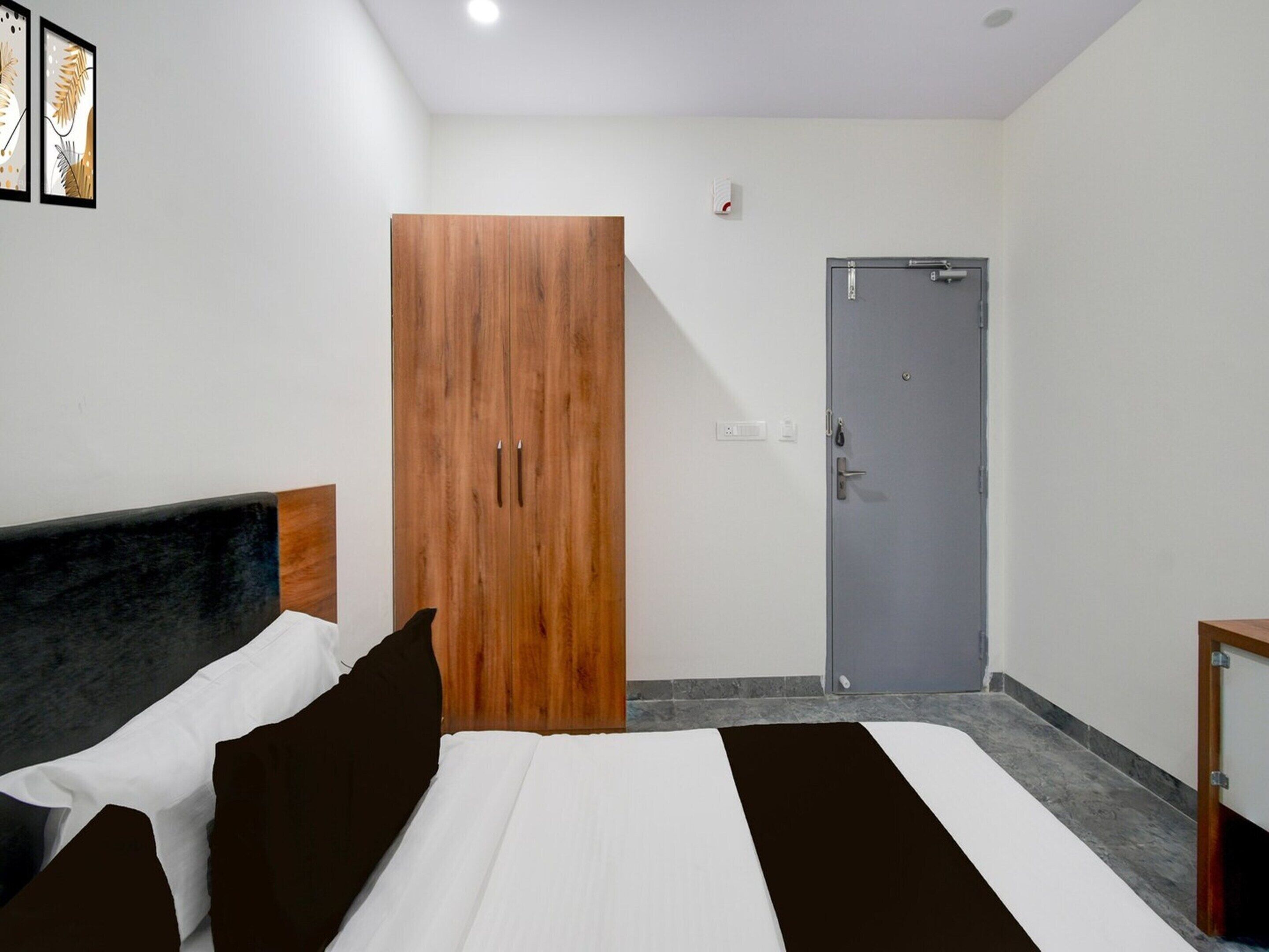 A bedroom with a bed, a wardrobe, and a door.