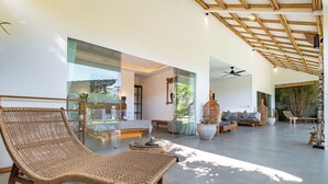 A spacious living area with a large wicker chair, a glass coffee table, and a sofa set. - Bingin Villas: Luxury, Concierge &  Security (Badung)