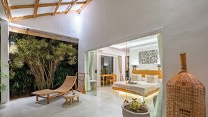 A modern interior with a lounge chair, a potted plant, and a bed in a well-lit room. - Bingin Villas: Luxury, Concierge &  Security (Badung)