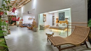 A modern interior with a high ceiling, a wicker lounge chair, a sofa, and a glass partition. - Bingin Villas: Luxury, Concierge &  Security (Badung)