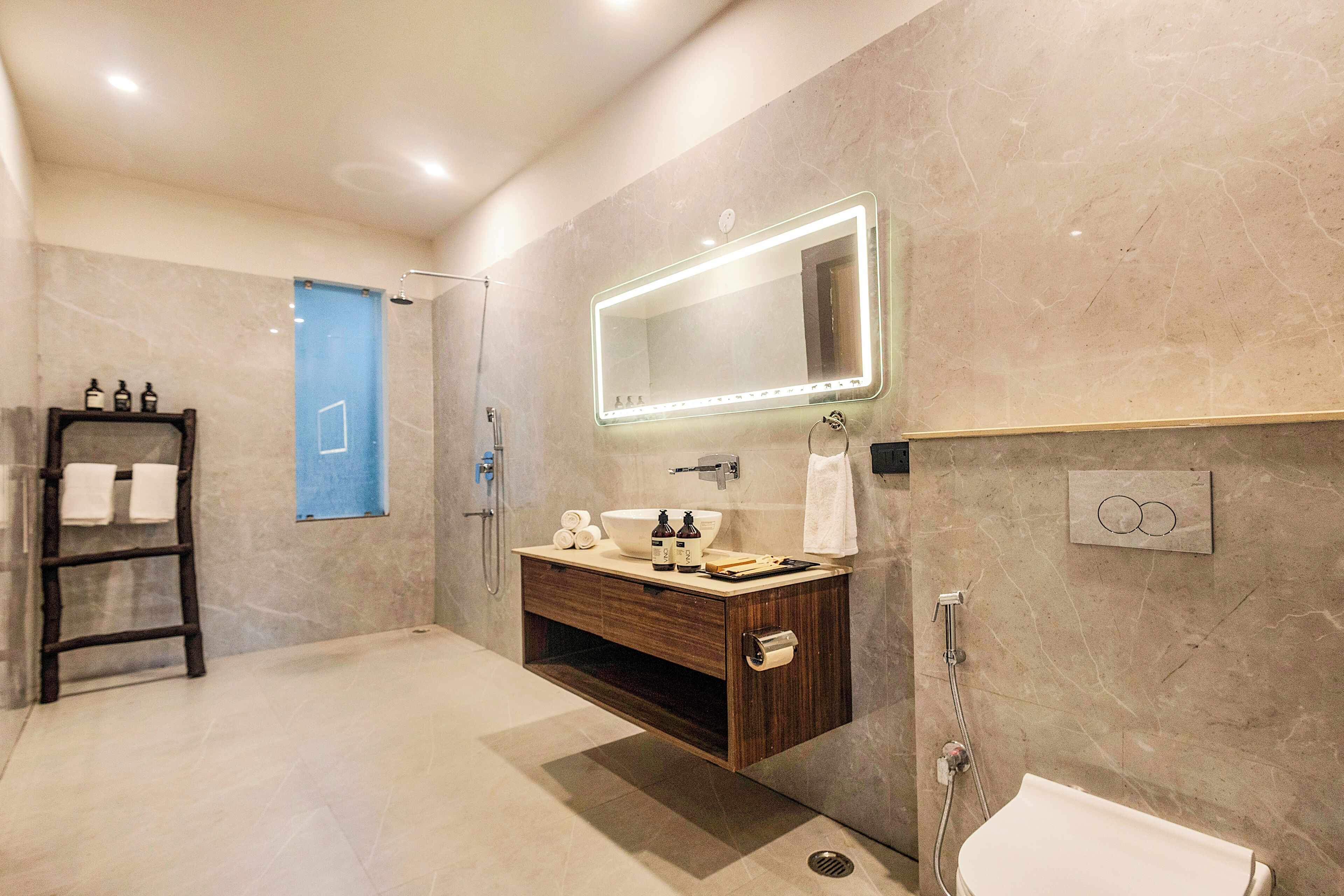 A modern bathroom with a vanity, mirror, shower, and a towel rack.
