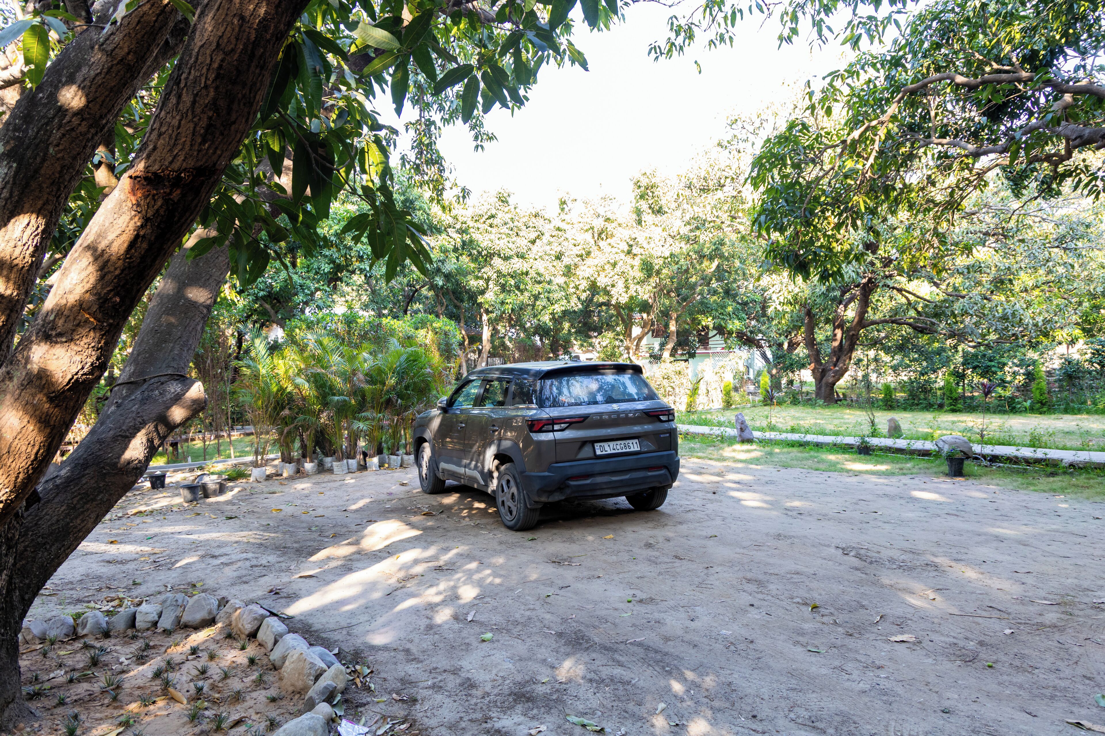 A vehicle parked in a natural setting with trees and a dirt path.