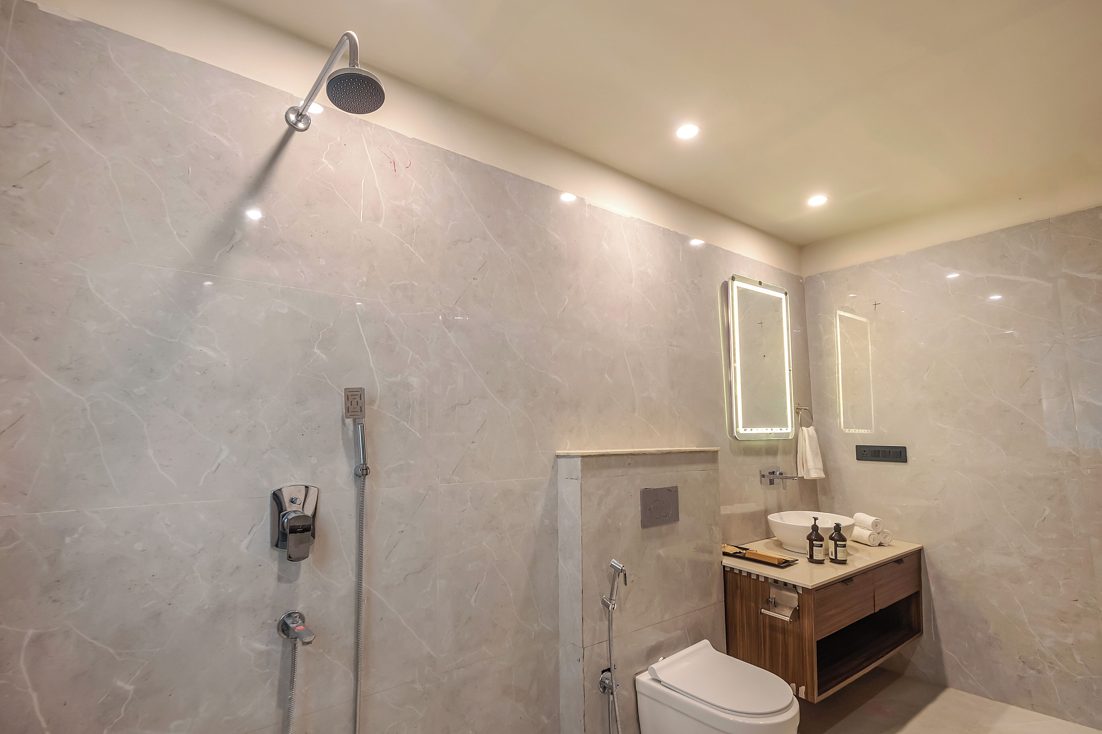 Un baño moderno con ducha, inodoro, tocador y espejos.