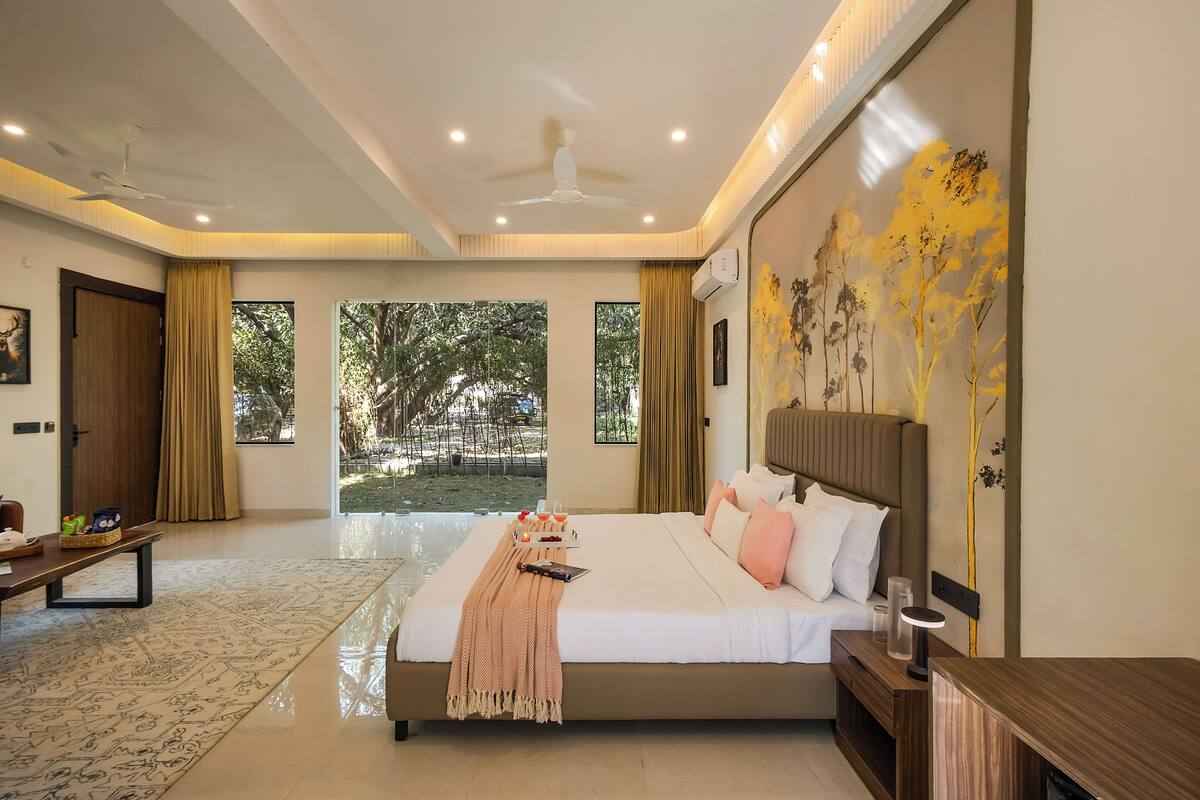 A spacious bedroom with a large bed, a ceiling fan, and a view of the outdoors.