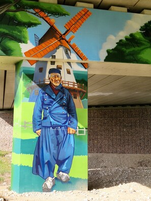 A mural of a windmill and a person in blue attire. - Bright, quietly located room, -2-, -close to the city in approx. 2 km- (Koblenz)