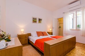 Ein Schlafzimmer mit Bett, Nachttischen, einem Schreibtisch und einem Fenster mit Vorhängen.