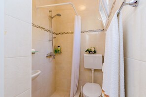 Ein Badezimmer mit Dusche, Toilette und Waschbecken.