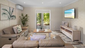 A modern living room with a sofa, coffee table, and TV.