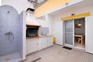 Eine kleine Küche mit Backofen, Spüle und Essbereich mit Tisch und Stühlen.