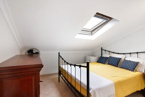 A bedroom with a bed, a desk, and a skylight. - Captivating Holiday Home in Manta Rota with Swimming Pool (Manta Rota)