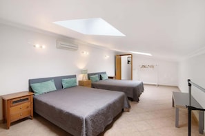A bedroom with two beds, a nightstand, a desk, and a skylight. - Captivating Holiday Home in Manta Rota with Swimming Pool (Manta Rota)