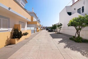 A narrow street with buildings on either side, a paved walkway, and a parked car. - Captivating Holiday Home in Manta Rota with Swimming Pool (Manta Rota)