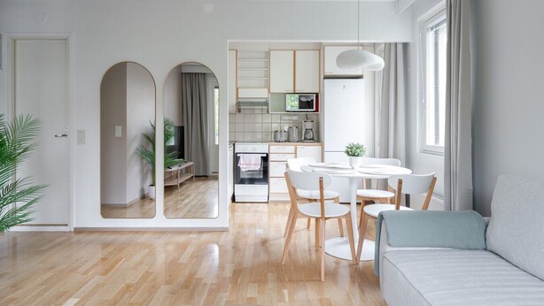 Eine moderne Wohnung mit Essbereich, Küche und Wohnzimmer mit Sofa.