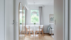 Ein modernes Interieur mit Essbereich, Holzboden und Blick auf Grünflächen.