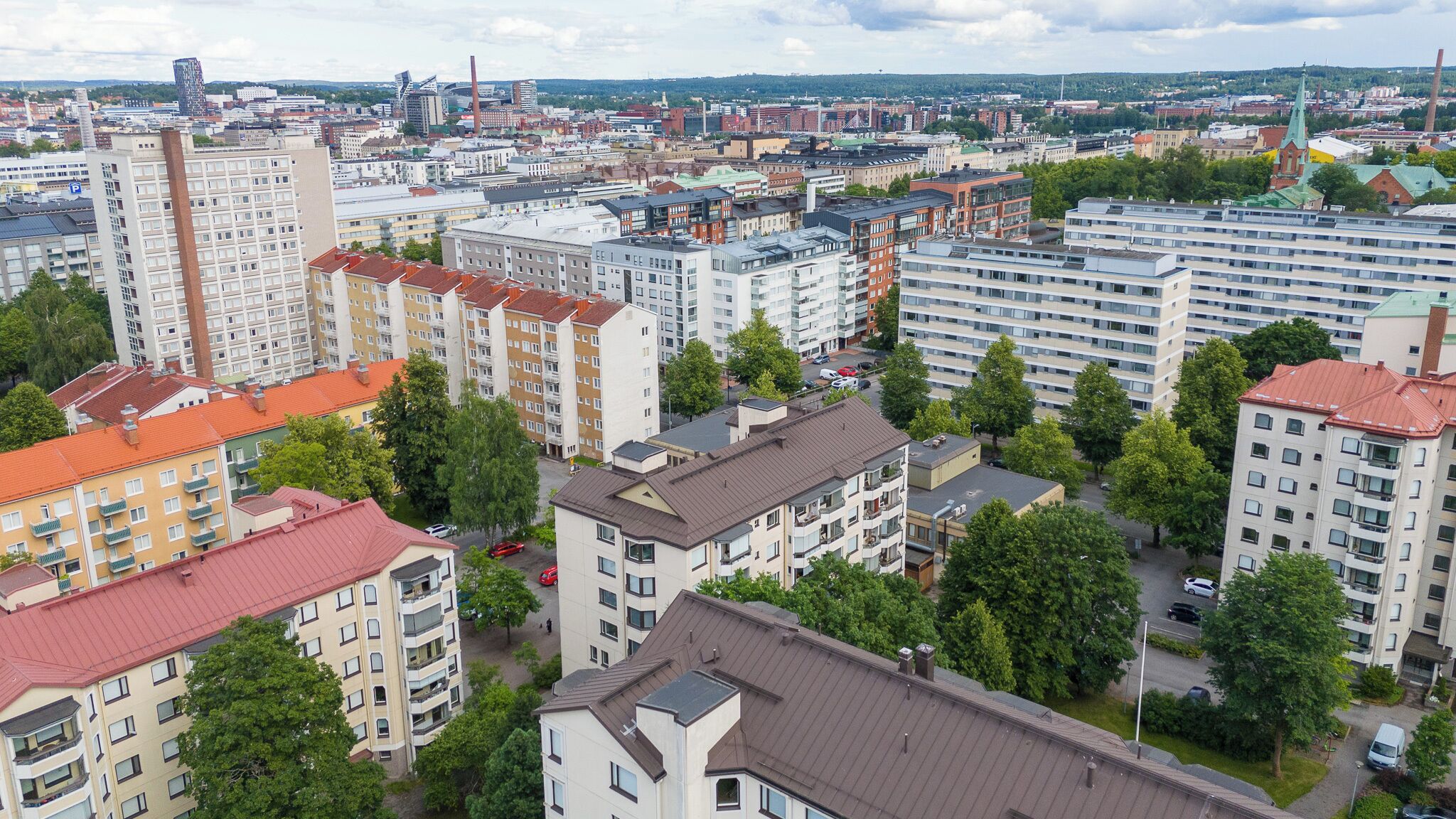 Een hoog complex van woongebouwen, met meerdere appartementencomplexen, waarvan sommige balkons hebben, en een combinatie van bouwstijlen.