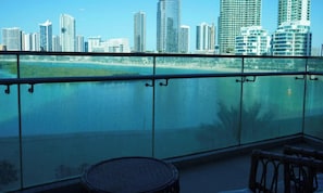 Un balcon offrant une vue sur les toits d’une ville et sur une étendue d’eau.