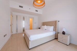 Una camera da letto con un letto, un comodino e una porta che dà su un'altra stanza.