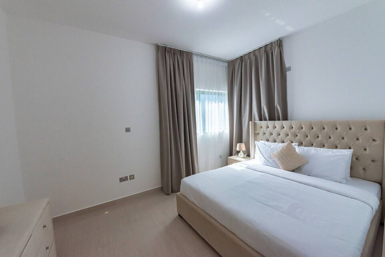 Une chambre d’hôtel avec un grand lit, une table de chevet et une armoire.