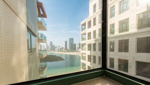 A high-rise building with a view of a beach and cityscape through a window. - Stylish Apt with Balcony & Views (Abu Dhabi)