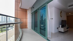 Un apartament modern amb un balcó, vistes a la ciutat i un interior minimalista.