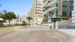 A modern residential building with a tiled courtyard, balconies, and a gated entrance. - Elegant 1BR in Reem Diamond, Abu Dhabi (Abu Dhabi)