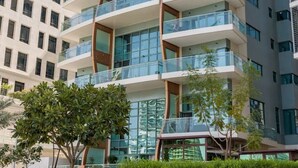 A multi-story building with balconies, large windows, and a modern architectural design.