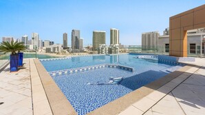 A rooftop pool with a city skyline view, surrounded by modern buildings.