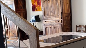 Una cucina con una scala in legno, un tavolo da pranzo e un armadio.