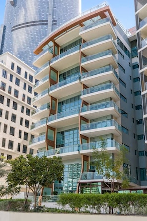 A multi-story building with balconies, large windows, and a modern architectural design. - Stylish 2BR Apt Next to the Beach (Abu Dhabi)