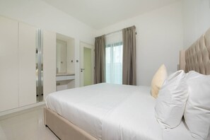 A modern hotel room with a large bed, a wardrobe, a bathroom mirror, and a window with curtains. - Elegant Escape 1BR in Al Reem Island Next to Beach (Abu Dhabi)