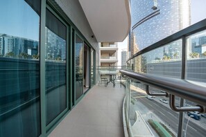 A balcony with a view of a cityscape, including tall buildings and a road with vehicles. - Elegant Escape 1BR in Al Reem Island Next to Beach (Abu Dhabi)