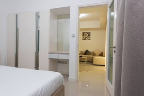 A bedroom with a bed, a wardrobe, and a bathroom visible through an open door. - Elegant Escape 1BR in Al Reem Island Next to Beach (Abu Dhabi)