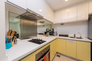 Una cocina moderna con estufa a gas, un lavamanos y armarios amarillos.