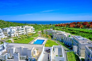 A modern hotel complex with multiple buildings, a swimming pool, and a view of the sea. - 3015 Luxury Serenity Views Apartment in Estepona (Buenas Noches)