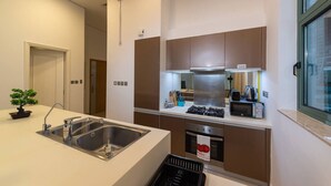 A modern kitchen with a stainless steel sink, a gas stove, and a built-in oven. - Beachfront 1BR with Huge Balcony in Al Reem Island (Abu Dhabi)