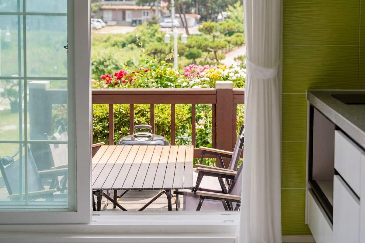 Una cocina con vista a una terraza de madera y jardín.