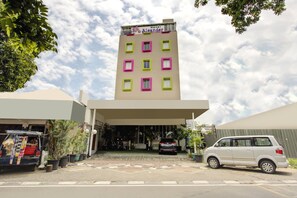 A hotel with a flat facade, multiple windows, and a car parked in front. - Luxury Deluxe DBL Retreat W/ Free Wifi and Parking (Jakarta)