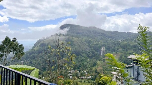 A mountainous landscape with a waterfall, greenery, and a building in the foreground. - Rokky Hill Cottage Ella (Ella)