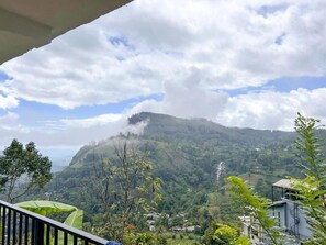 A mountainous landscape with a waterfall, greenery, and a building in the foreground. - Rokky Hill Cottage Ella (Ella)