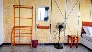 A room with a wooden ladder, a standing fan, a small wooden stool, and a window with a checkered blind. - Rokky Hill Cottage Ella (Ella)