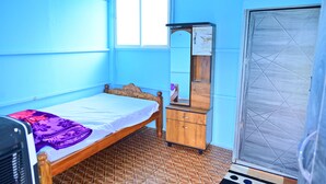 Quarto com cama, cómoda de madeira, espelho e janela.