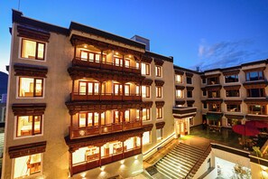 Ein mehrstöckiges Hotel mit Balkonen, einer Treppe und Au ßenplätzen.