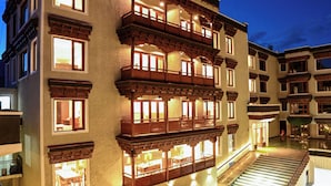 Un hotel de varios pisos con un estilo arquitectónico tradicional, que cuenta con balcones y una entrada bien iluminada.
