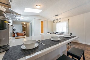 Une cuisine moderne dotée d’un îlot central, d’appareils électroménagers intégrés et d’un coin repas offrant une vue agréable.