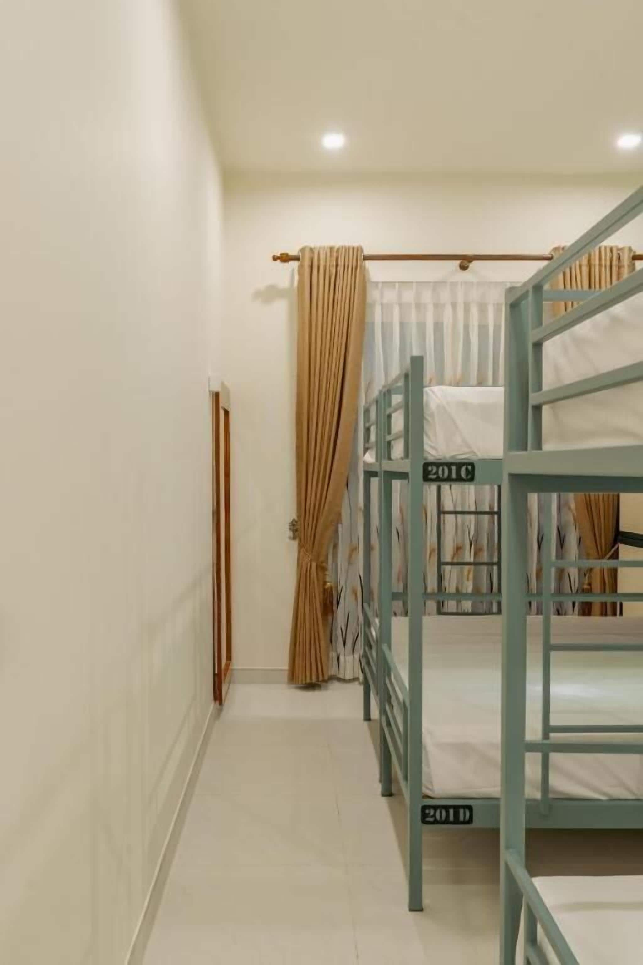 A narrow hallway with bunk beds labeled '2010' and '2011' in a dormitory setting.