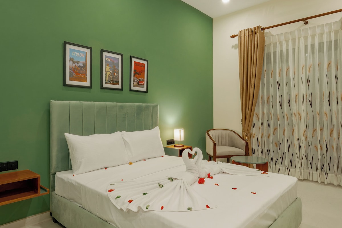 A hotel room with a bed, a chair, a nightstand, a ceiling fan, and a window with curtains.