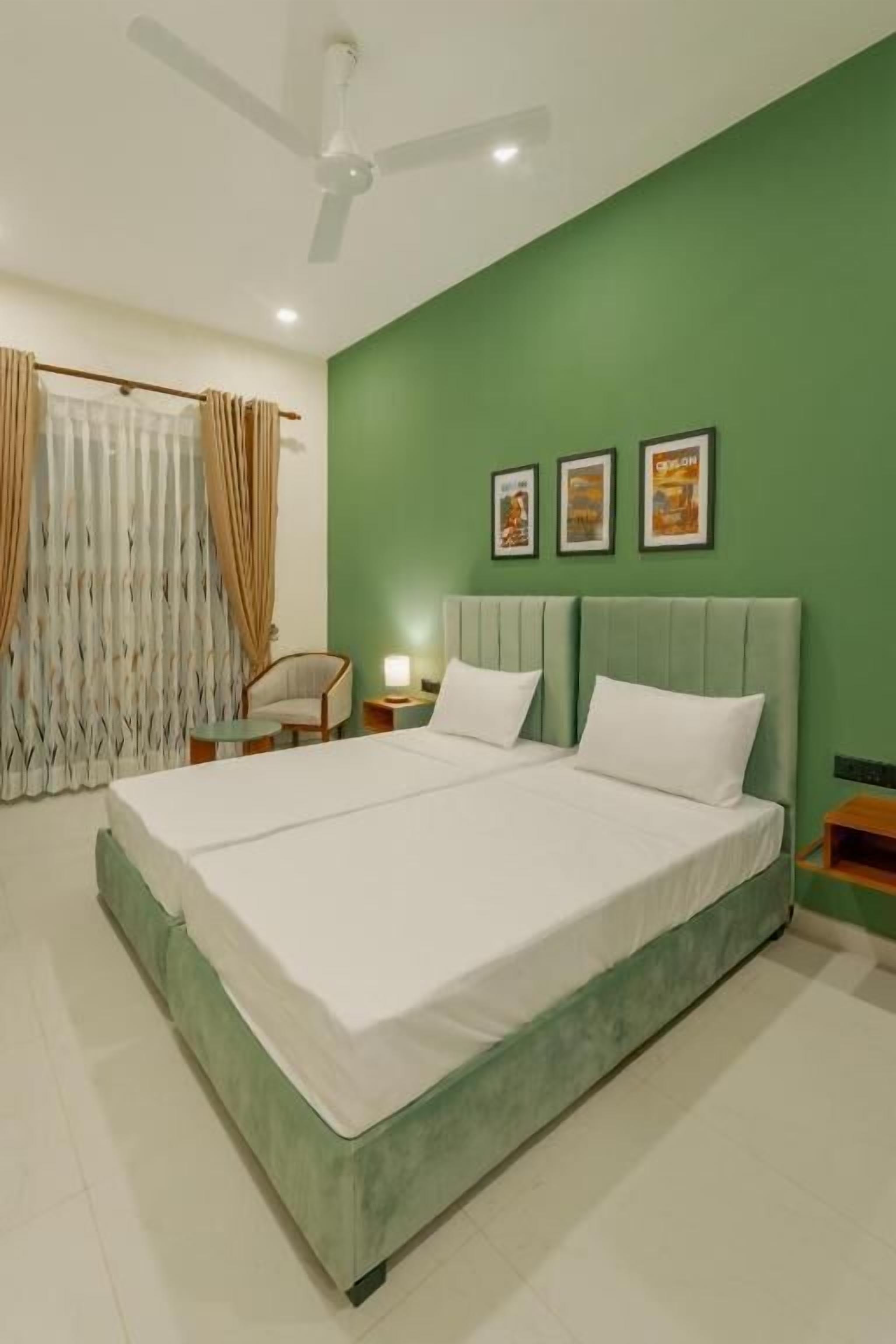 A bedroom with a bed, a ceiling fan, a nightstand, and a chair.