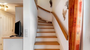A staircase with wooden steps and a white wall. - Apartment "Kiel" with Shared Terrace, Garden, and Wi-Fi (Pellworm)