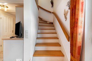 Una escalera con escalones de madera y una pared blanca.